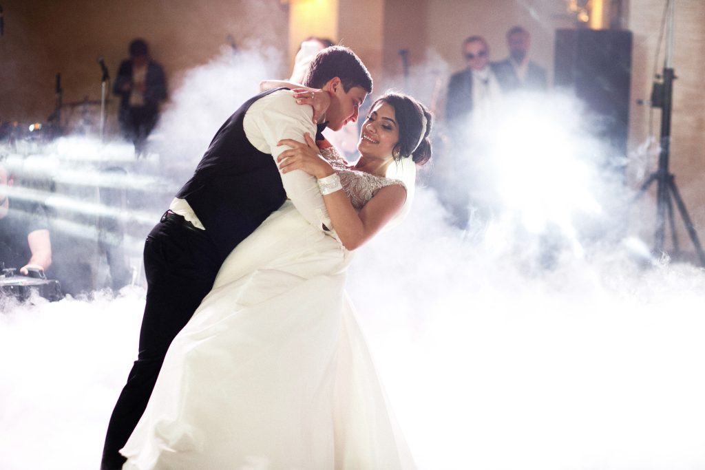 Smoke surrounds dancing wedding couple in the hall
